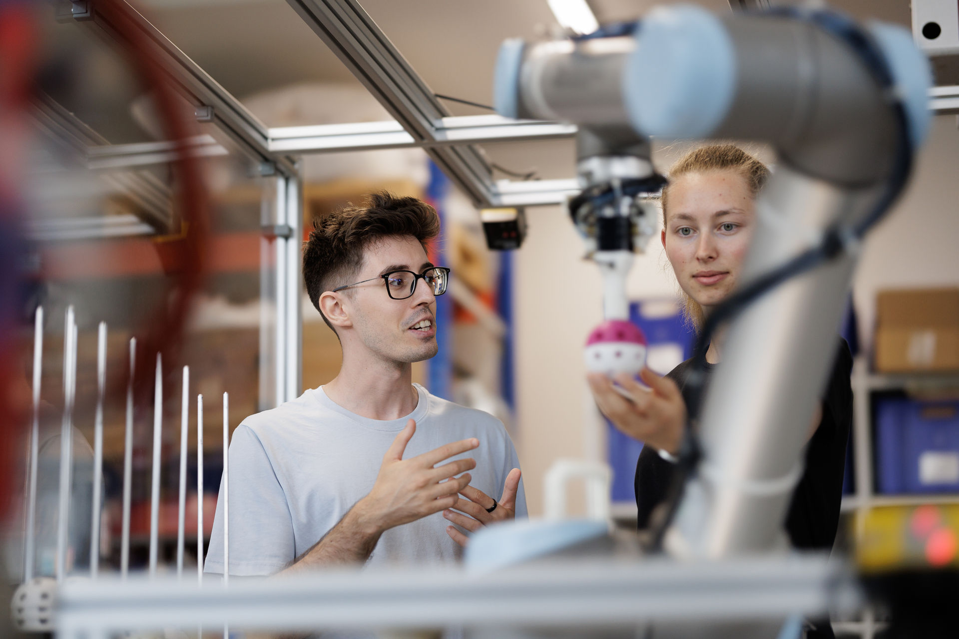 Zwei Studierende im Studiengang Maschinentechnik | Innovation arbeiten an einer Automatisierungsanlage.