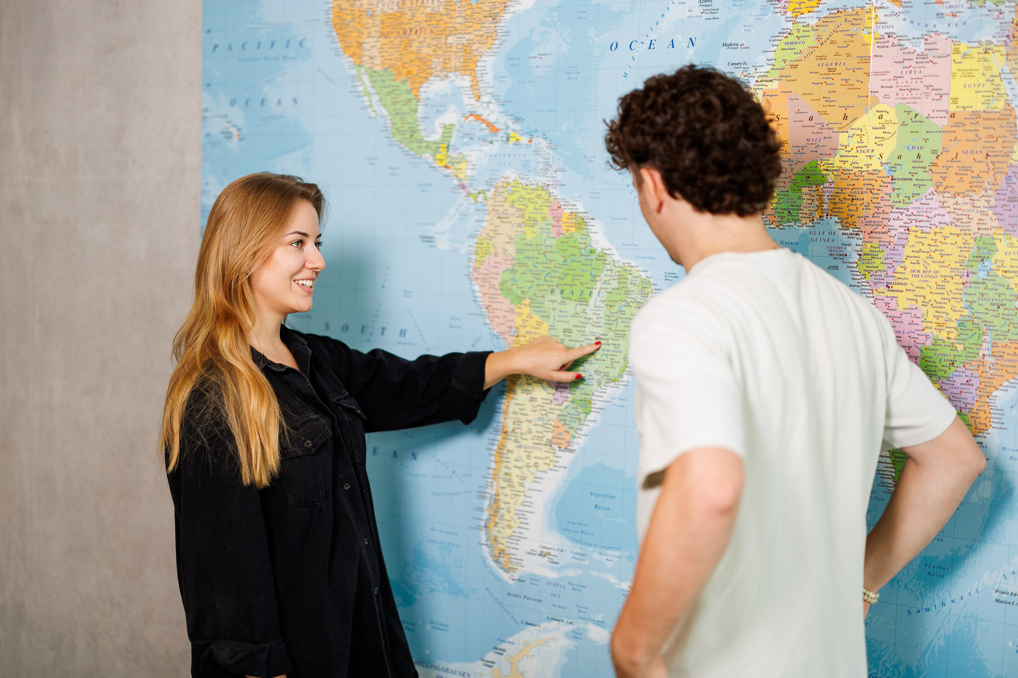 Zwei Studierende in International Management betrachten gemeinsam die Weltkarte.