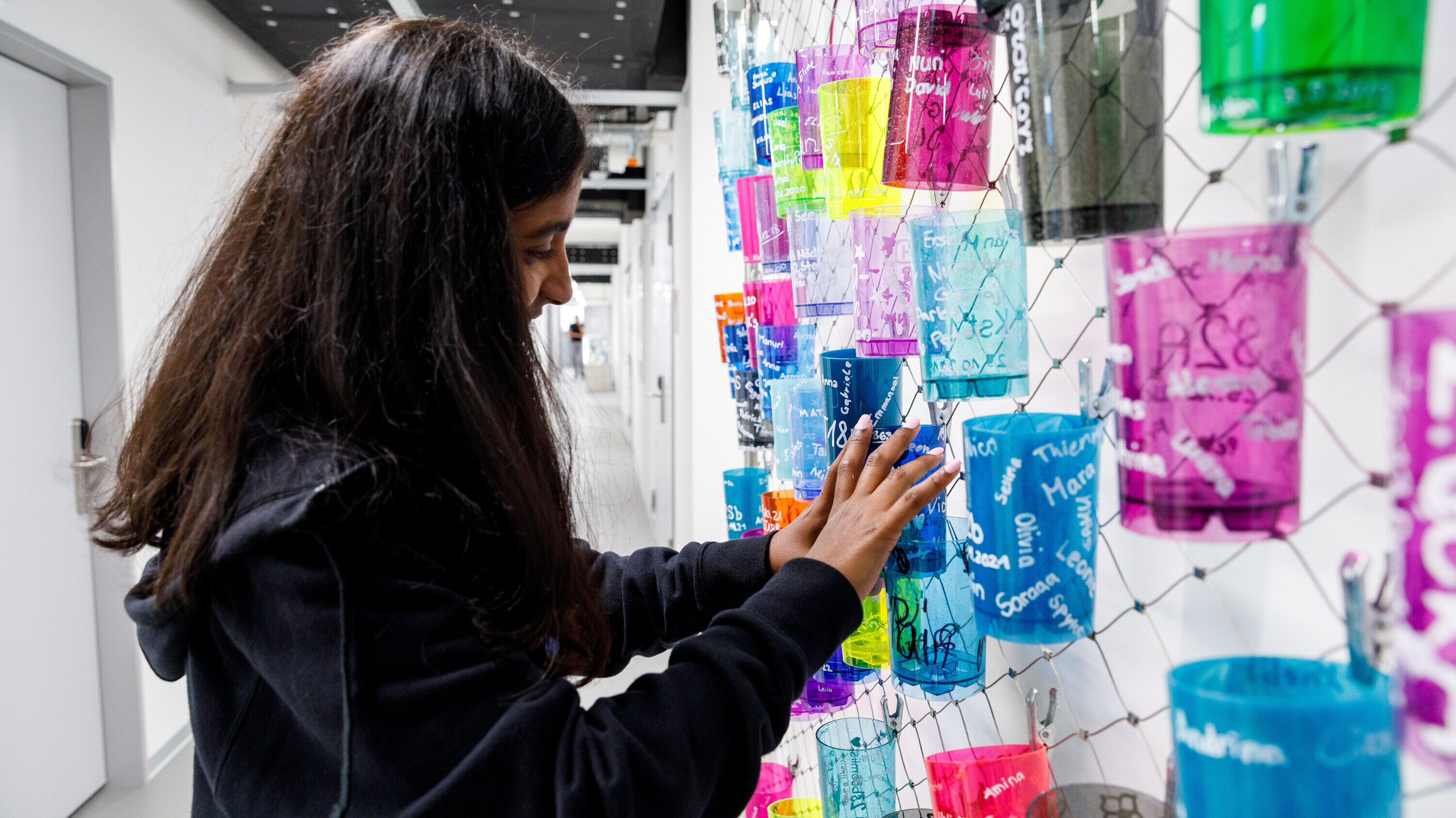 2022_ostlab_jugendliche_becherwand Jugendliche befestigt Becher an Wand im OSTLAB