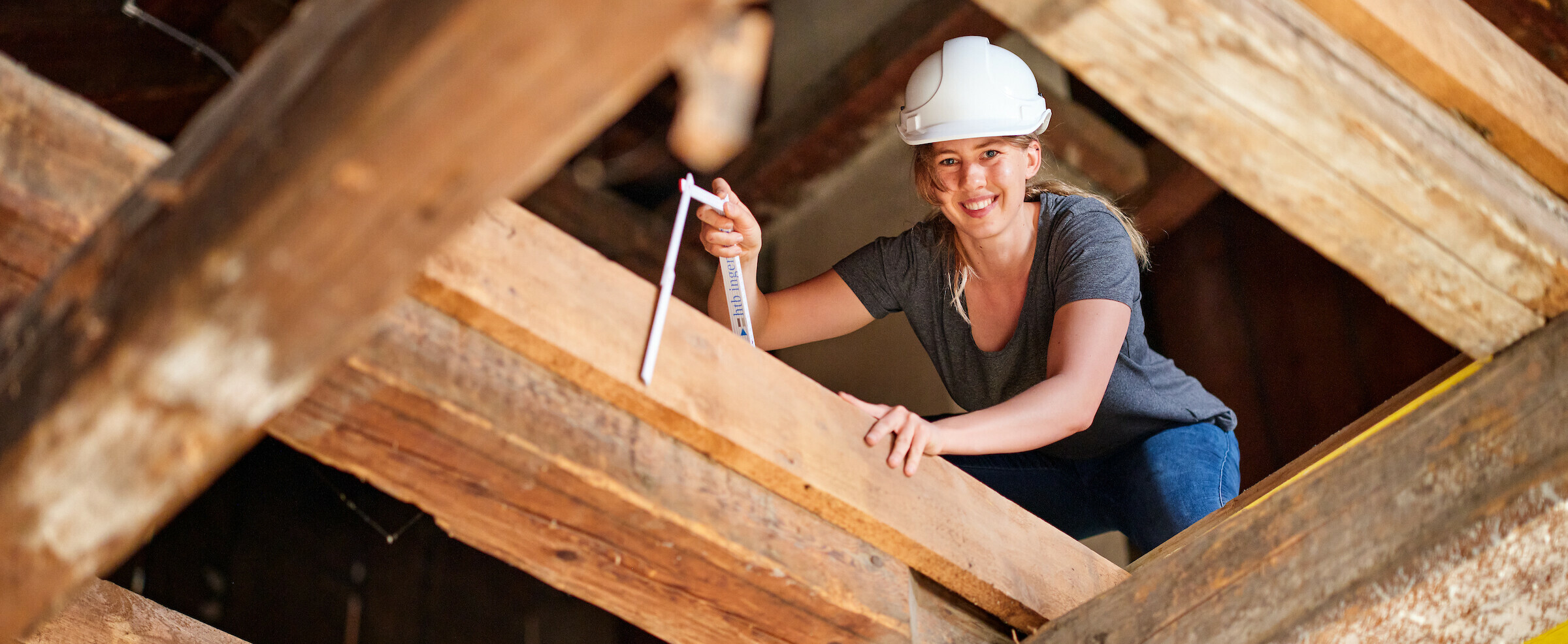 Studentin des Bachelor Bauingenieurwesen auf hölzernen Dachkonstruktion