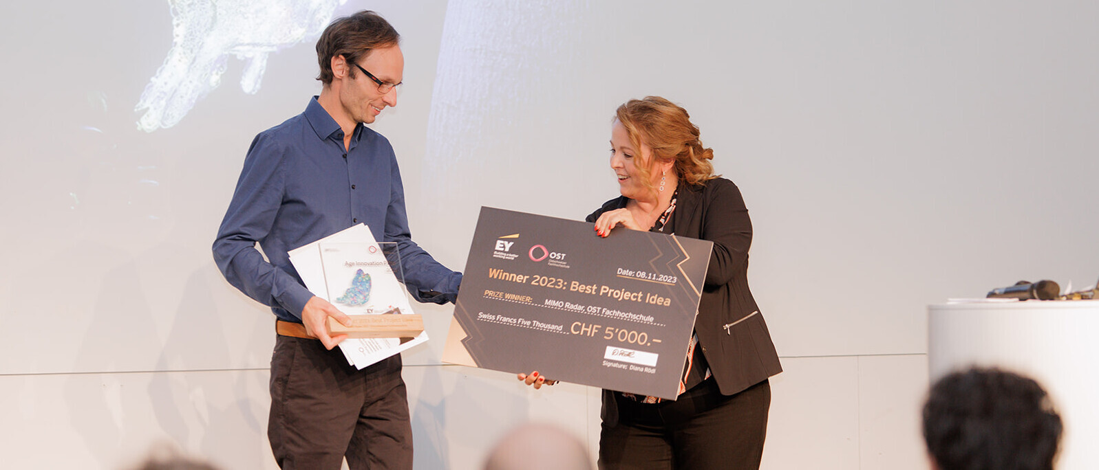 Age Innovation Preis 2023: Michael Gottinger, ESA Institut für Elektronik, Sensorik und Aktorik der OST – Ostschweizer Fachhochschule, erhält den Preis für die beste Projektidee (MIMO Radar) von Diana Rödl, Director Emerging Technology EY Schweiz. Age Innovation Preis 2023: Michael Gottinger, ESA Institut für Elektronik, Sensorik und Aktorik der OST – Ostschweizer Fachhochschule, erhält den Preis für die beste Projektidee (MIMO Radar) von Diana Rödl, Director Emerging Technology EY Schweiz.