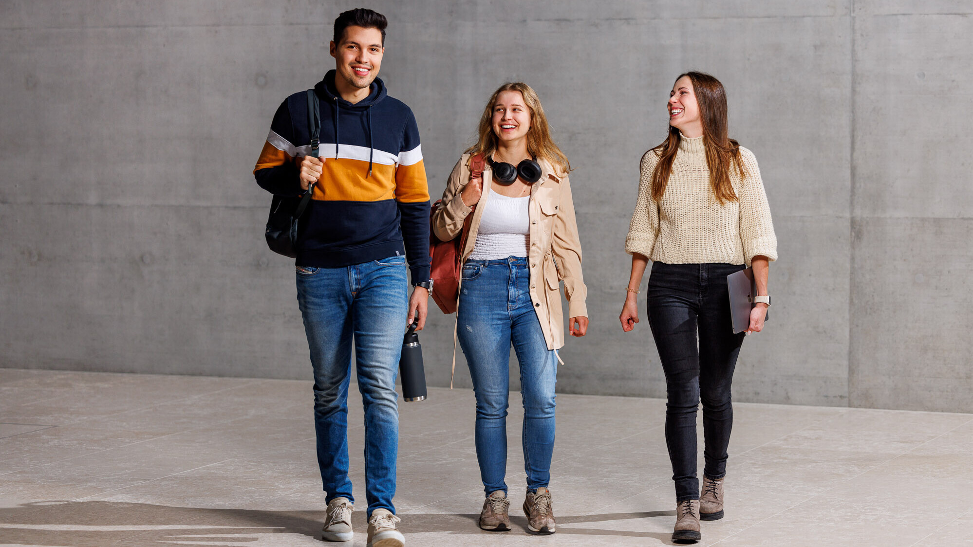 Zwei Bachelorstudentinnen und ein Student der OST vor grauer Wand