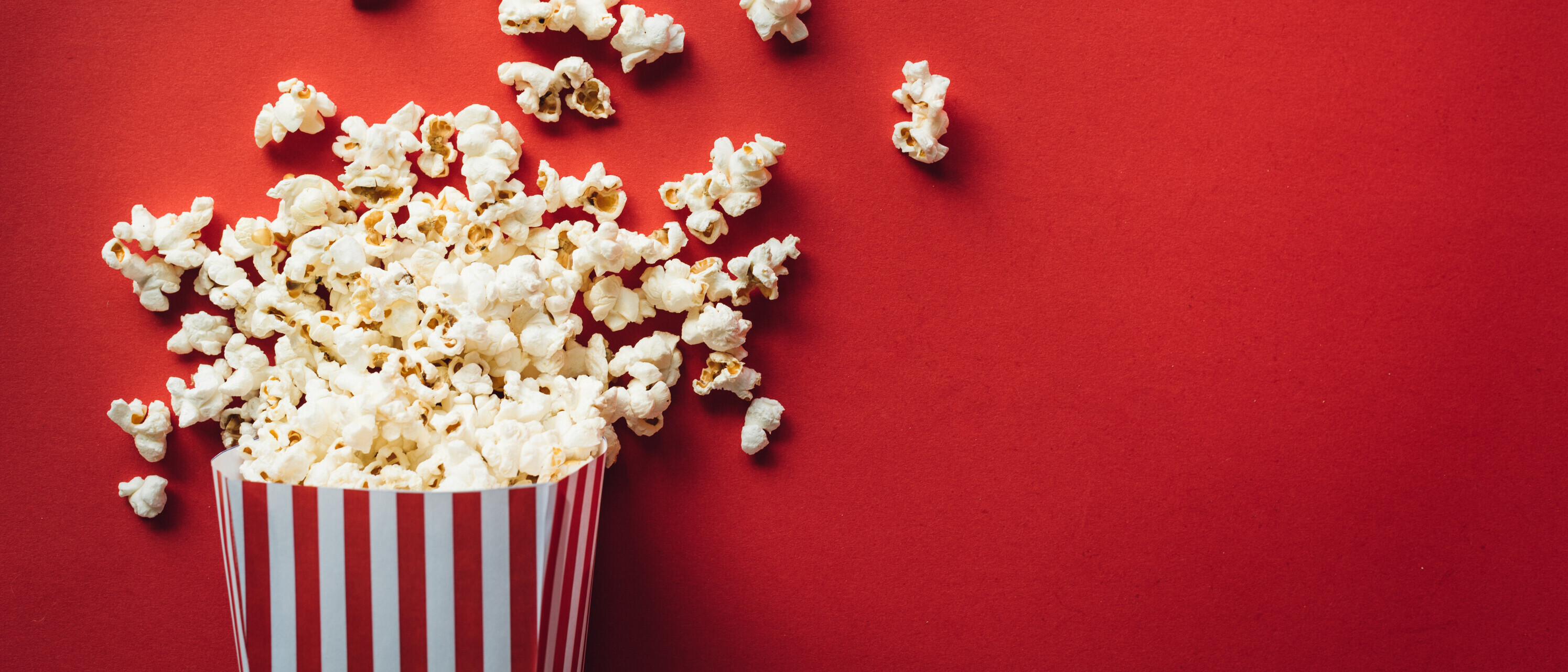 Striped box with popcorn Popcorn vor rotem Hintergrund