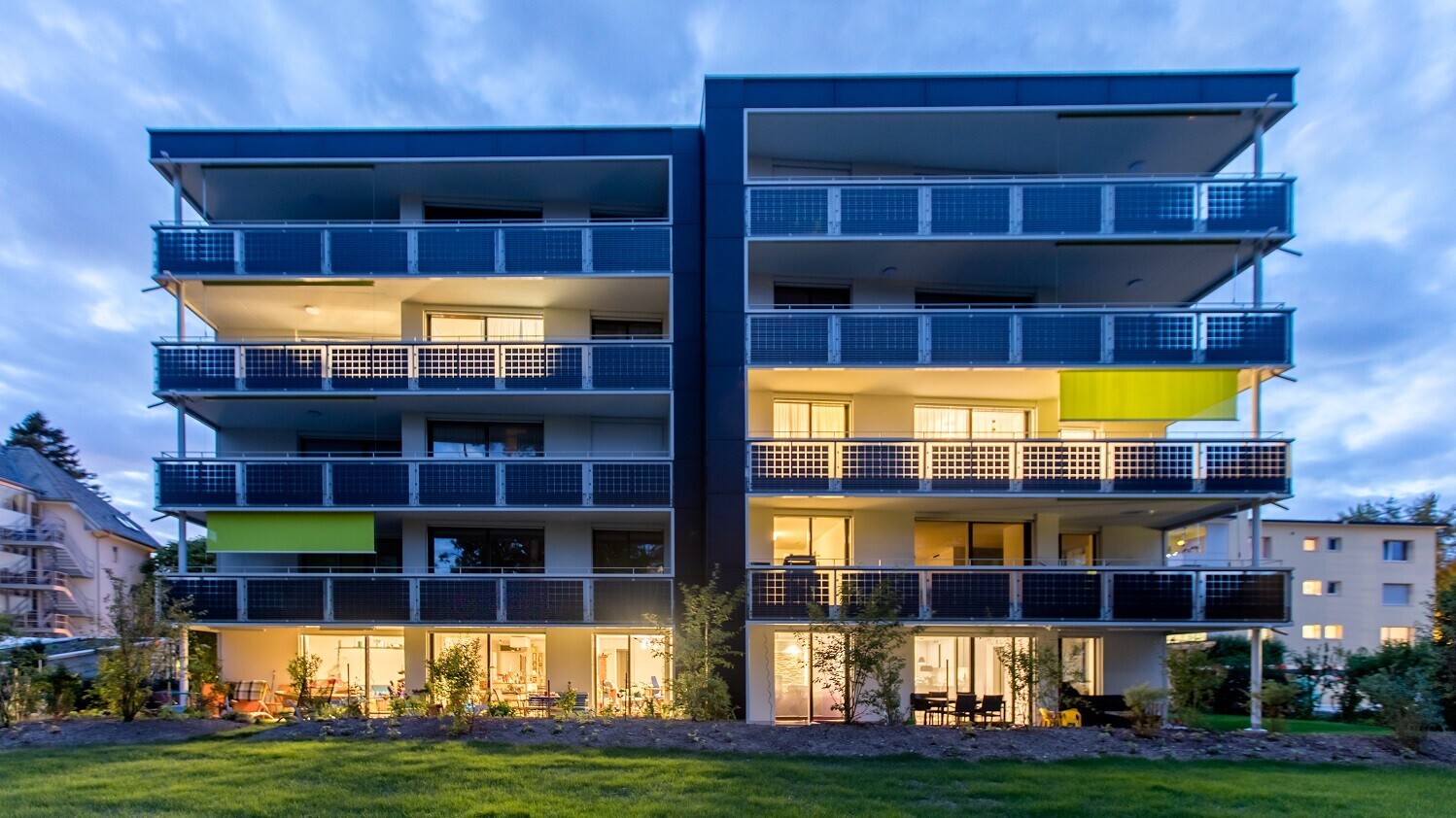 Solarhaus in der Abenddämmerung mit erleuchteten Fenstern (Symbolbild für Gebäudetechnik)