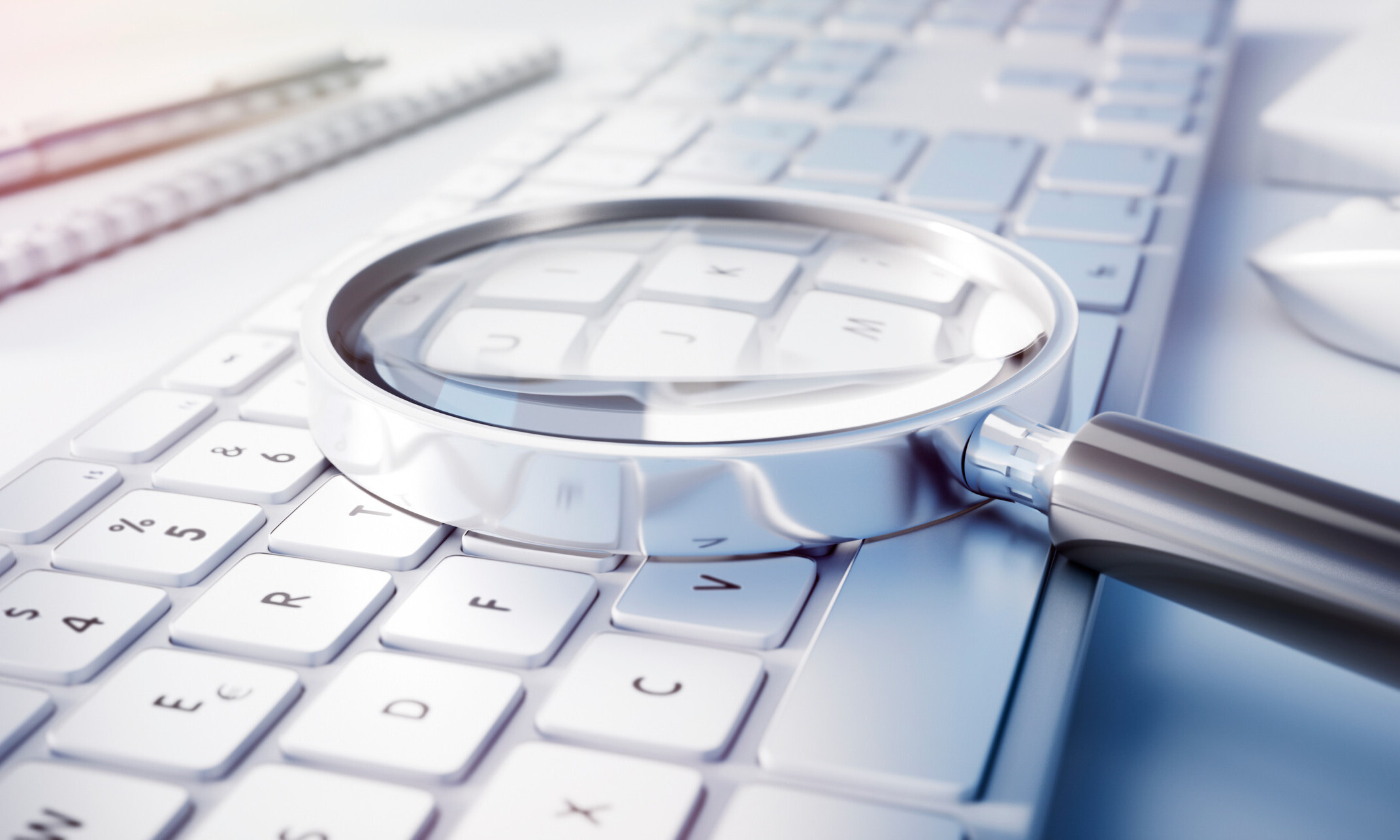 Magnifying glass on computer keyboard - search technology concep