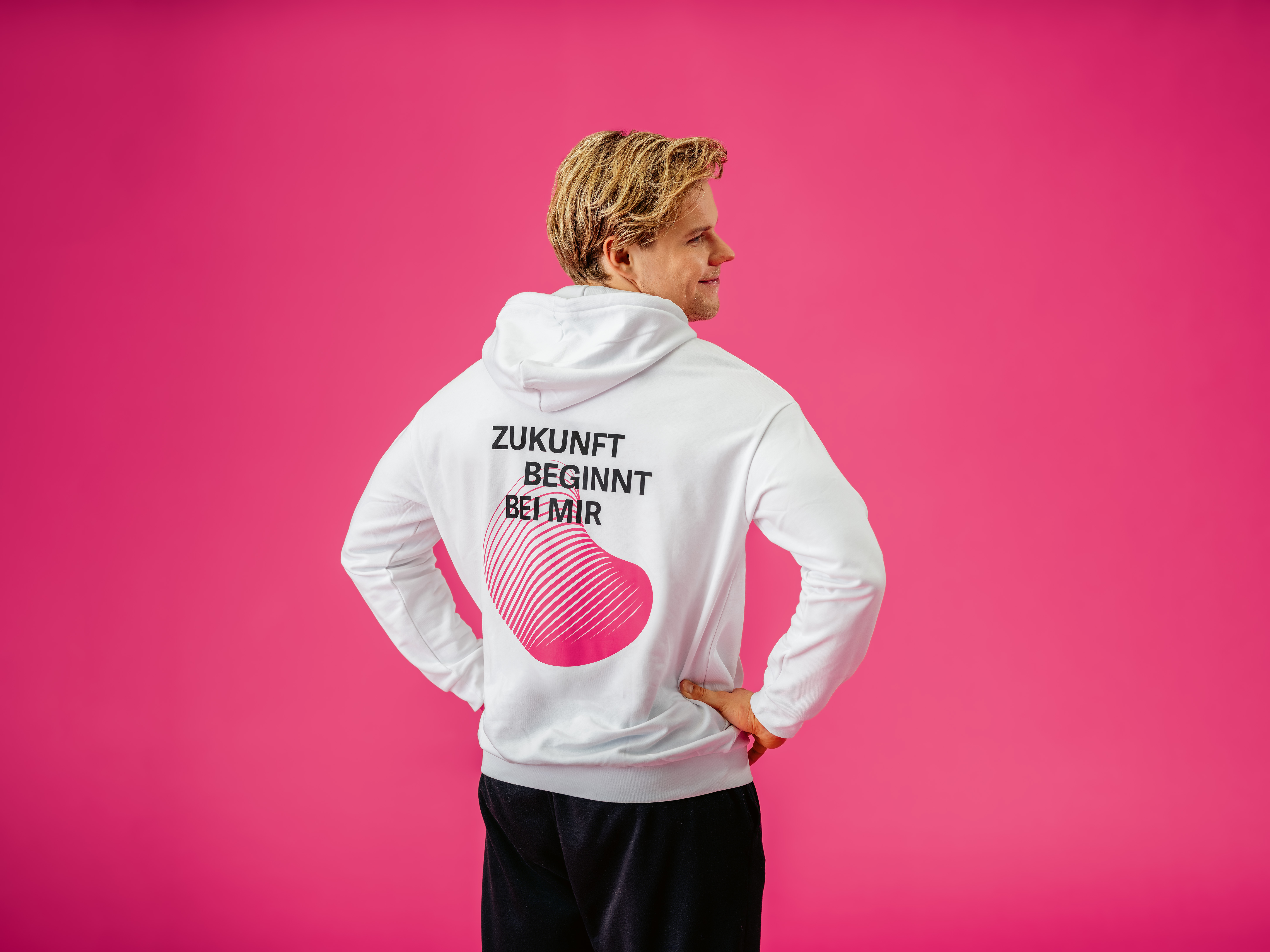Ingenieur-Kampagne OST Richard Ein junger Mann in weissem Hoodie mit Slogan "Zukunft beginnt bei mir" vor pinkfarbenen Hintergrund
