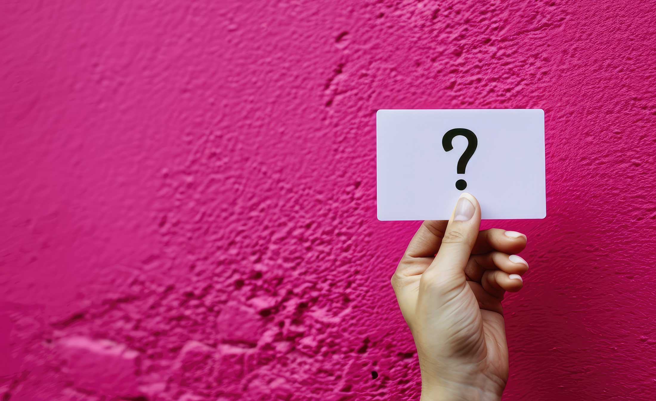 FAQ oft gestellt Fragen rund um das Studium - und passende Antworten Hand hält eine Karte mit einem Fragezeichen als Symbol für FAQ