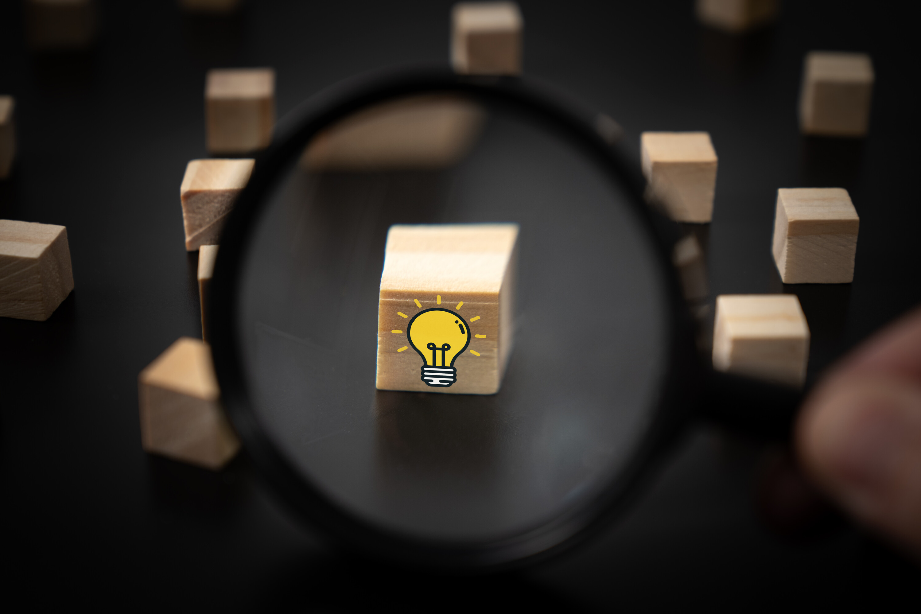 Magnifying glass searching for a good idea light bulb