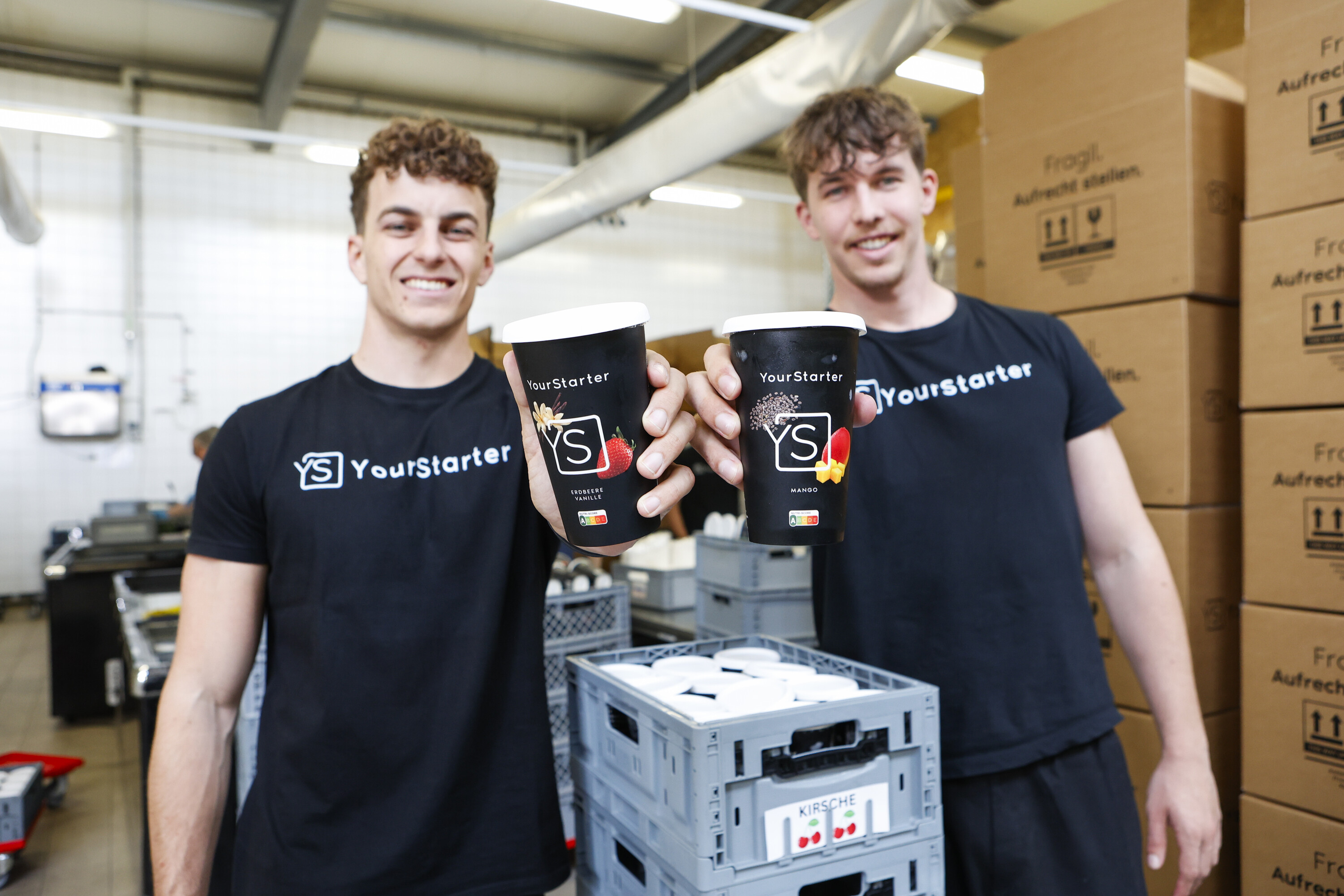 Fabian und Nando Lüchinger stehen in ihrer Produktionshalle in Oberriet und halten ihr Produkt, die Frühstücksdrinks Starter, in den Händen.